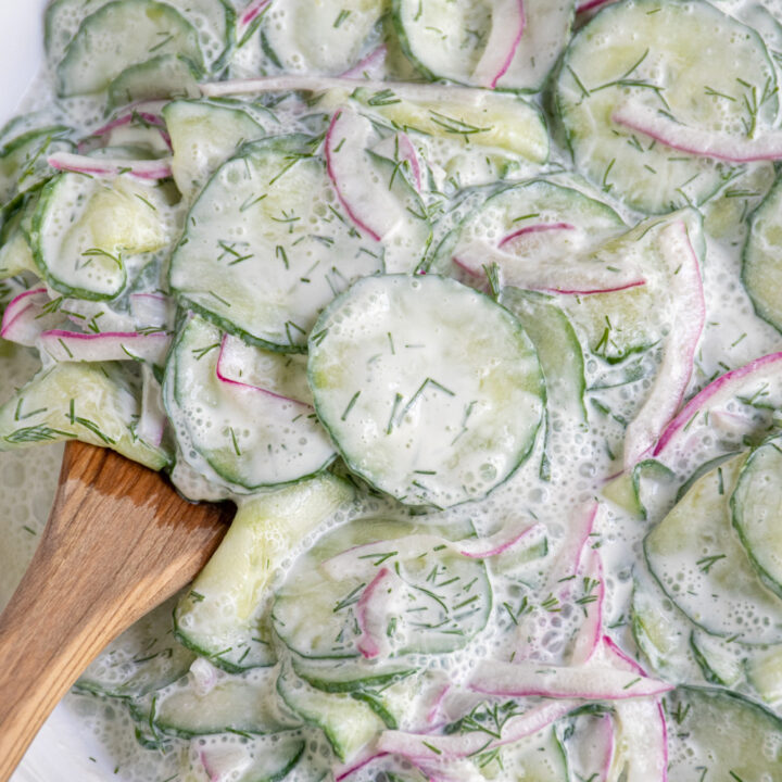 Close up of creamy cucumber salad with sour cream in a bowl.