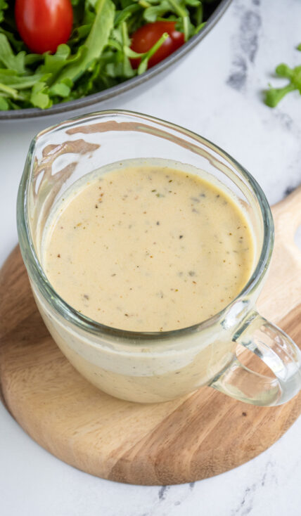 Serving jar filled with creamy hummus salad dressing.