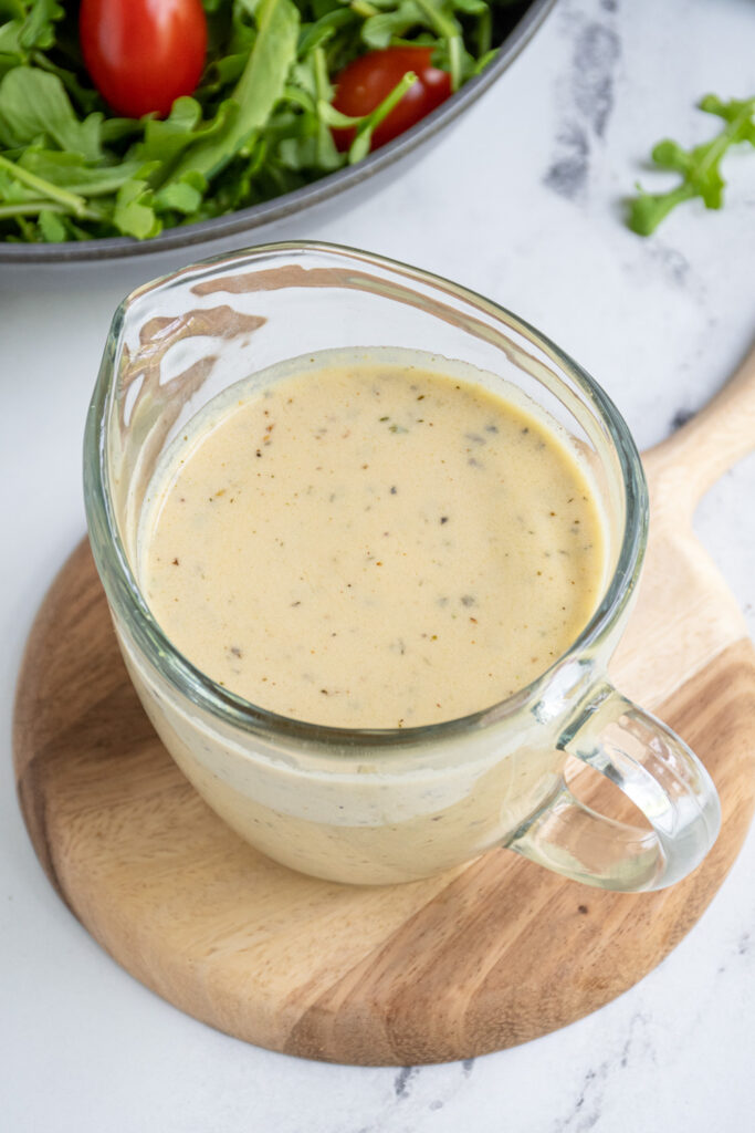 Serving jar filled with creamy hummus salad dressing.