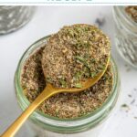 Pinterest Pin with text overlay "Greek Seasoning Recipe", image of a jar with a resting spoon full of greek seasoning.