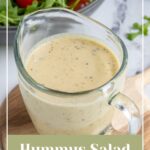 Pinterest pin with text overlay "Hummus Salad Dressing", image of a serving glass filled with creamy hummus salad dressing.