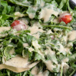 Pinterest pin with text overlay "Hummus Salad Dressing", image of a salad covered in hummus salad dressing.