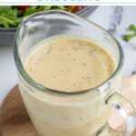 Pinterest pin with text overlay "Hummus Salad Dressing", image of a serving glass filled with creamy hummus salad dressing.