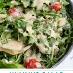 Pinterest pin with text overlay "Hummus Salad Dressing", image of a salad covered in hummus salad dressing.