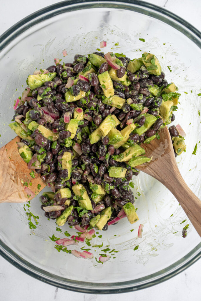 Mixing the black bean avocado salsa together in a mixing bowl.