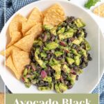Pinterest Pin with text overlay "Avocado Black Bean Salsa", image of a white bowl with black bean avocado salsa and tortilla chips.