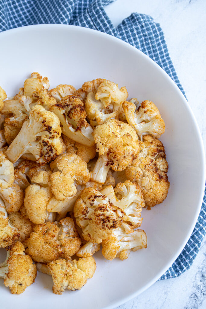 Overhead view of a white bowl with air fryer cauliflower in it.