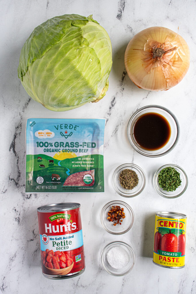 Ingredients needed to make slow cooker unstuffed cabbage rolls laid out on a tabletop.