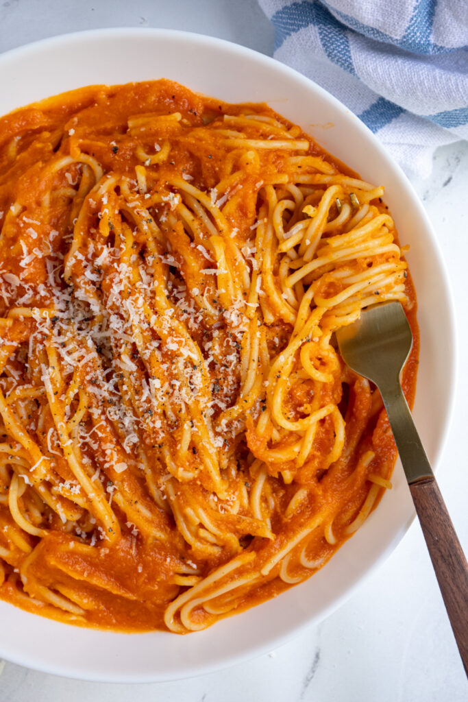 Overhead view of a pasta bowl filled with spaghetti covered in butternut squash pasta sauce.