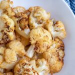 Pinterest pin with text overlay "Air Fryer Cauliflower", image of a bowl of crispy cauliflower roasted in the air fryer.