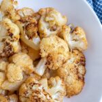 Pinterest pin with text overlay "Air Fryer Cauliflower", image of a bowl of crispy cauliflower roasted in the air fryer.