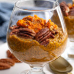 Pinterest Pin with image of a glass with pumpkin chia seed pudding topped with pecans.