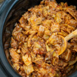 Pinterest pin with text overlay "Slow Cooker Unstuffed Cabbage Rolls", image of crockpot with cooked lazy cabbage rolls.
