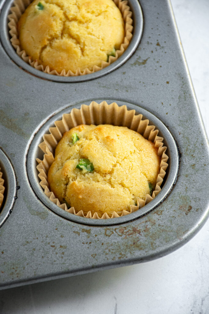 Close up of a jalapeño cornbread muffin in a muffin tin.