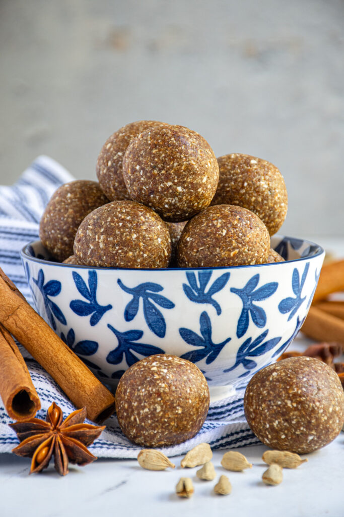 A blue and white bowl filled with chai spiced energy balls.