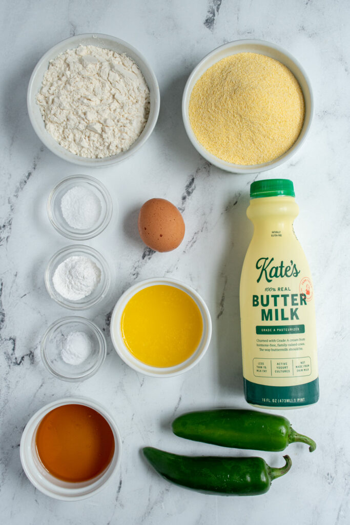 All the ingredients needed to make jalapeño cornbread muffins laid out on a tabletop.