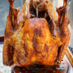 Pinterest pin with text overlay 'The Best Deep Fried Turkey Recipe', image of a golden brown deep fried turkey.