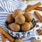 Pinterest pin with text overlay "Chai Spiced Energy Ball", image of a blue and white bowl overfilled with chai spiced energy bites.