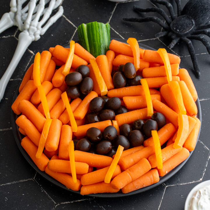 An angled look at a pumpkin veggie tray for halloween served with hummus or ranch.