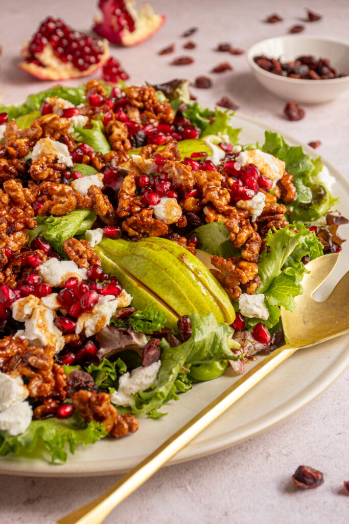 Close up of a winter salad on a large platter with candied walnuts.