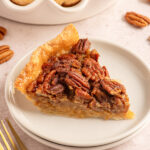 Pinterest pin with text overlay 'Bourbon Pecan Pie', image of a slice of pecan pie on a white plate.