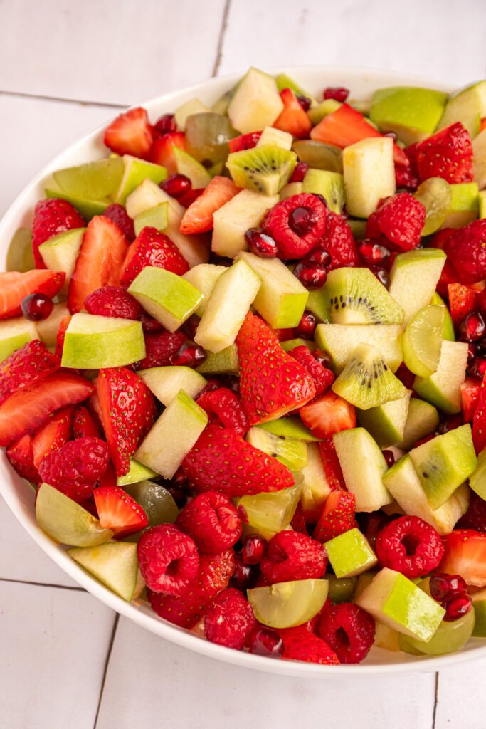 A bowl of red and green fruit to make Christmas fruit salad.