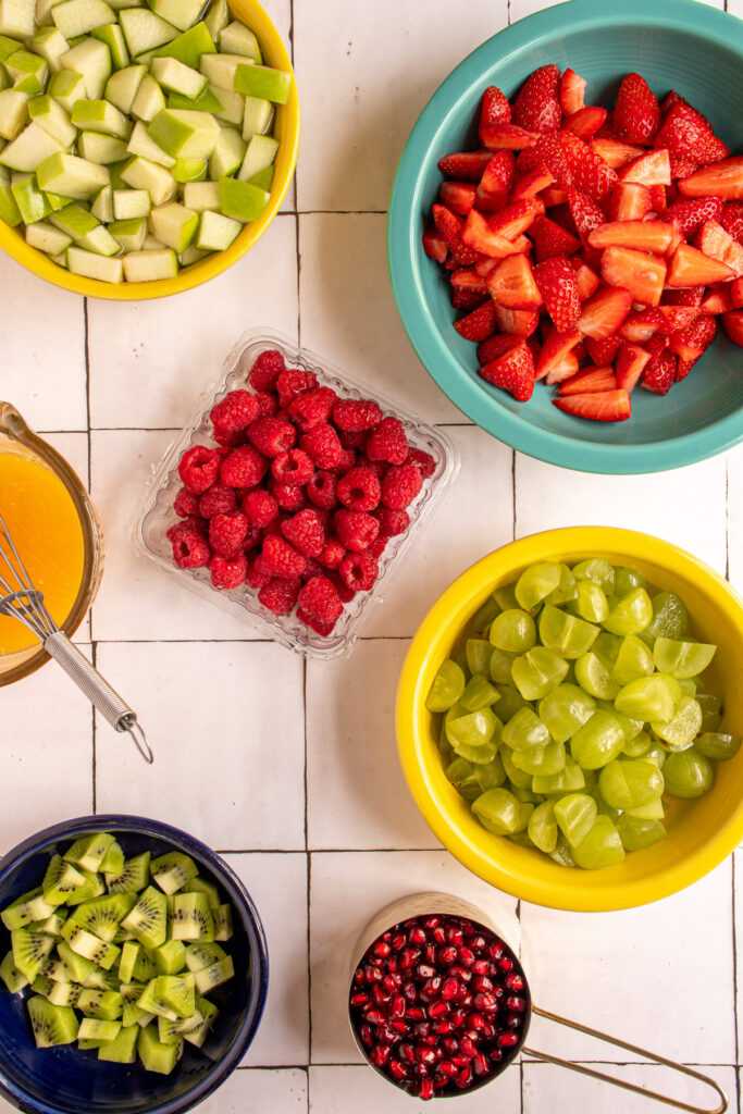 The red and green fruits in individual bowls to make Christmas fruit salad.