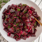 Pinterest pin with text overlay 'Simple Beet Salad', image of a serving bowl filled with beet salad topped with fresh dill.