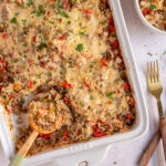 Pinterest pin with text overlay "Stuffed Pepper Casserole", image of a white baking dish with stuffed bell pepper casserole with a wooden spoon.