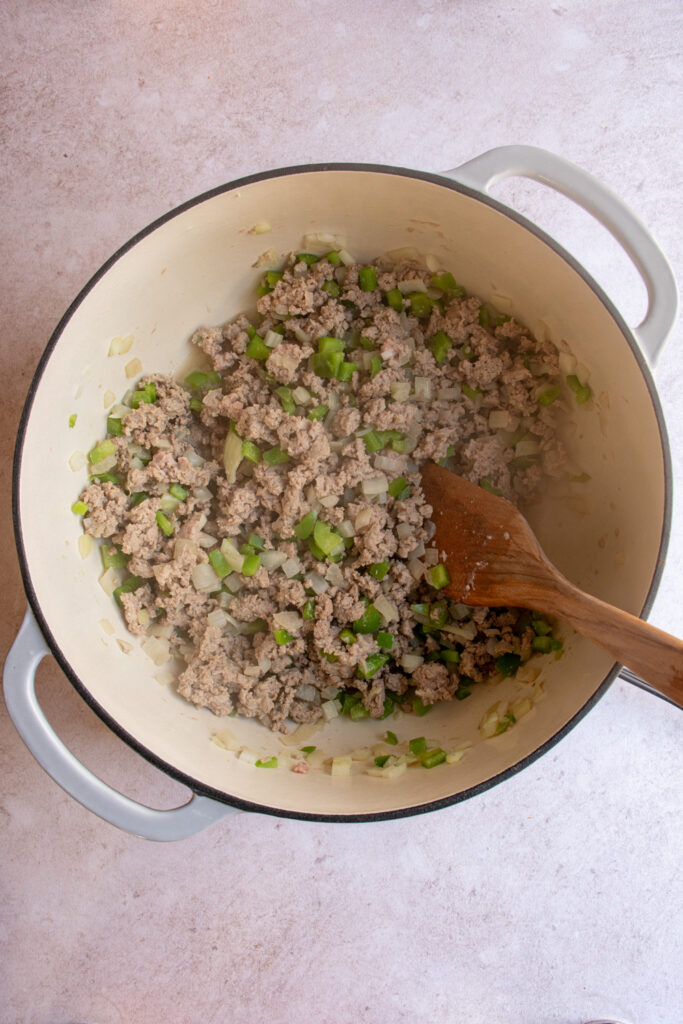 A large pot browning the ground turkey with onions and green bell pepper.