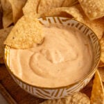 Pinterest pin with text overlay 'cottage cheese queso', image of a small yellow bowl surrounded by chips with cottage cheese queso.