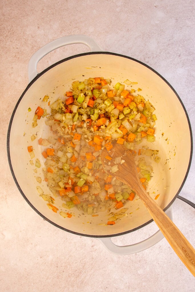 A large dutch oven inside sautéing veggies.