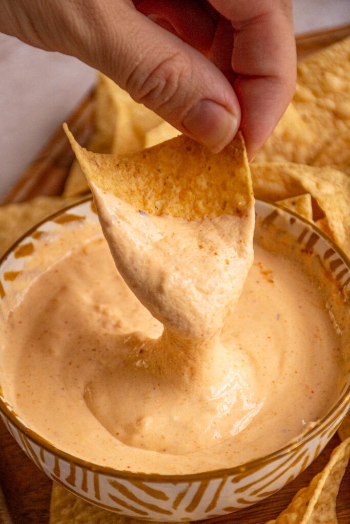 A tortilla chip dipped into cottage cheese queso.