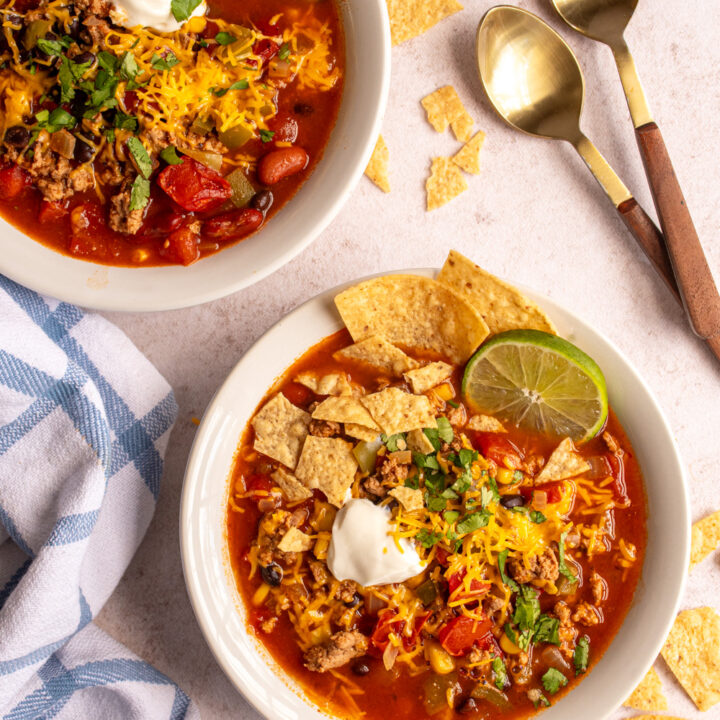 Overhead view of soup bowls filled with turkey taco soup with garnishes.