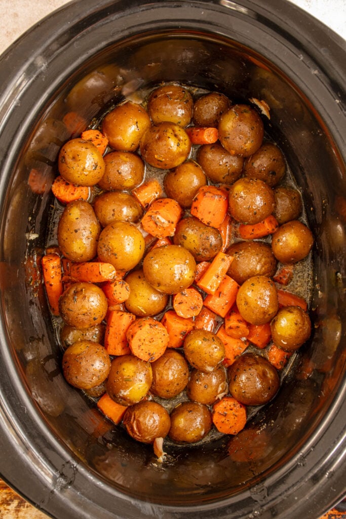 Cooked carrots and baby potatoes in a crockpot.