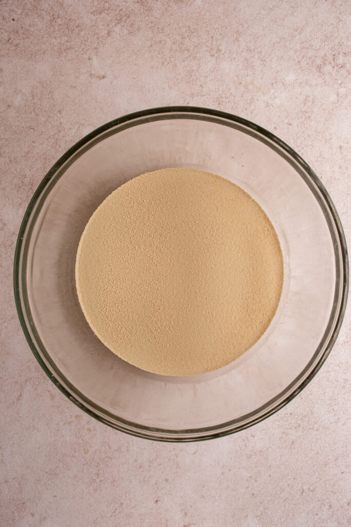 Adding yeast and warm water together for focaccia dough.