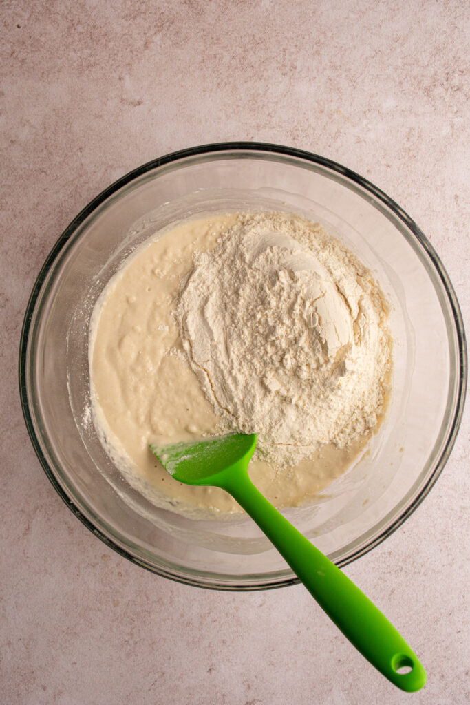 Mixing the second batch of flour into the dough for focaccia bread.