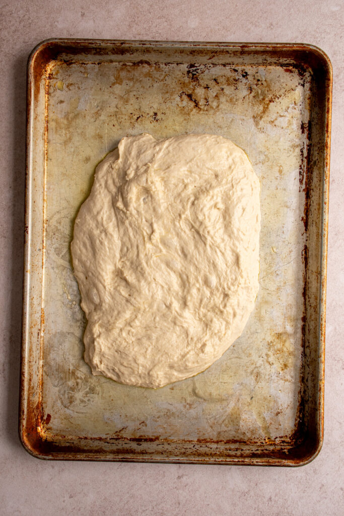 focaccia dough on an oiled sheet pan.