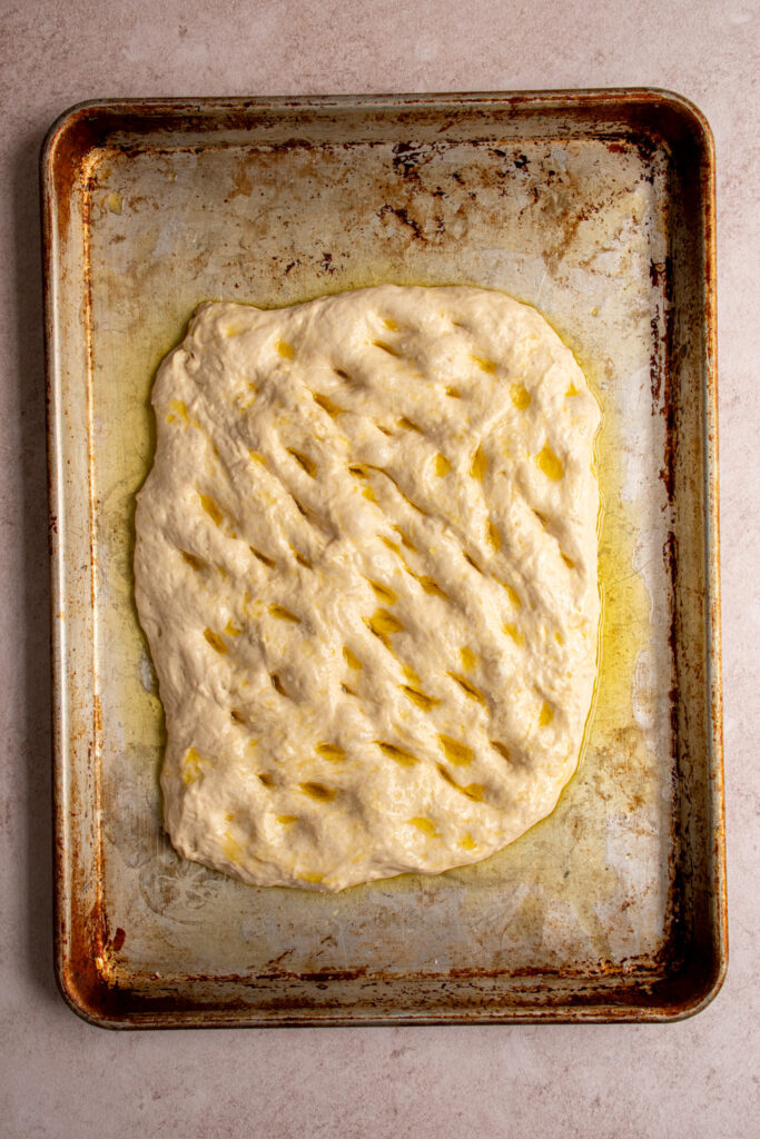 Oiled and dimpled focaccia bread ready for the oven.