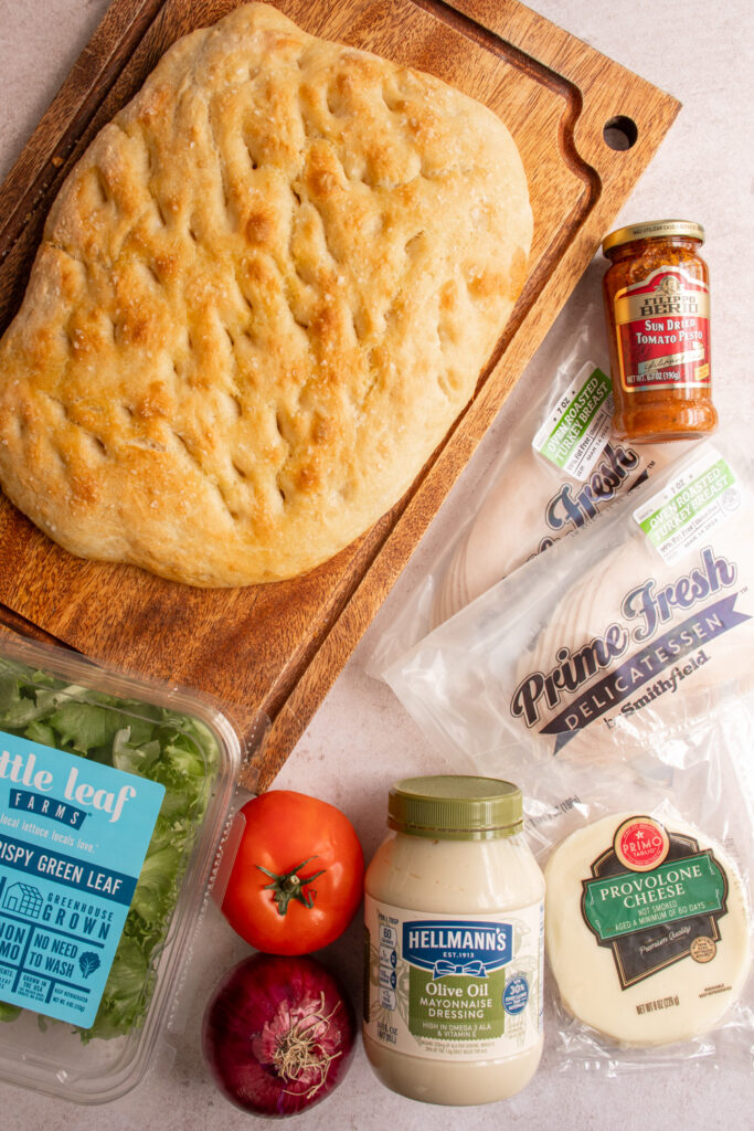 Ingredients to make a focaccia turkey sandwich laid out on a tabletop.