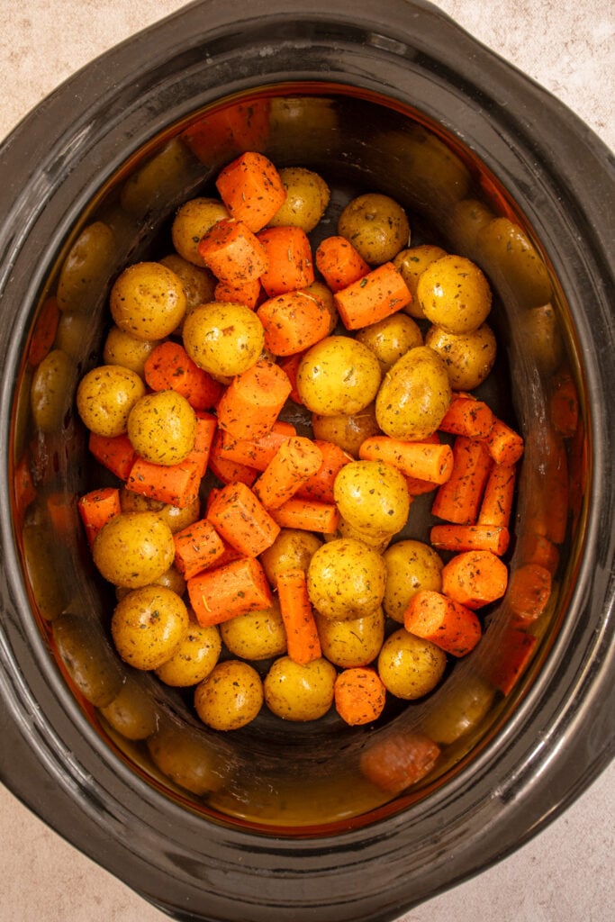 Seasoned carrots and baby potatoes added to the crockpot.