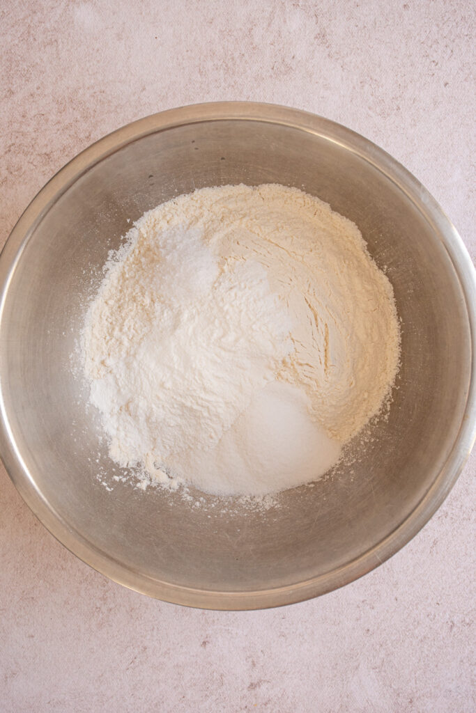Adding the dry ingredients to a bowl for Banana Chocolate Chip Pancakes.