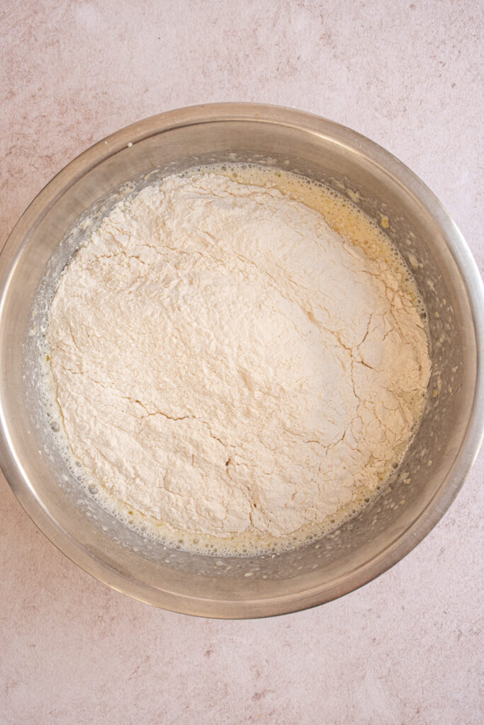 Adding the dry ingredients to the wet ingredients to make pancake batter.