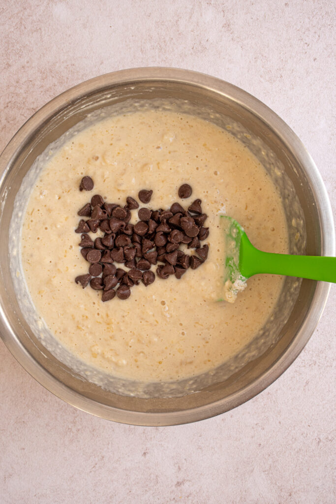 Adding chocolate chip pancakes to the batter to make Banana Chocolate Chip Pancakes.