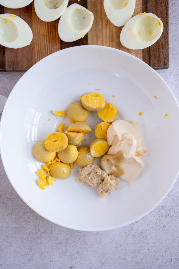 A bowl with egg yolks, mayo, horseradish, mustard, and salt.
