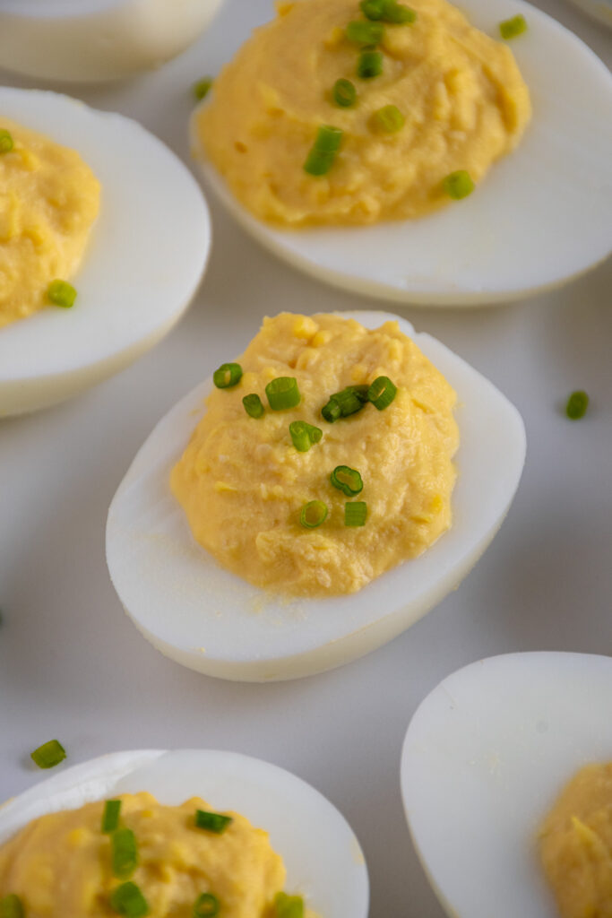 Close up of a Horseradish Deviled Egg on a white plate.