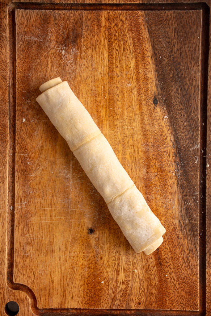 A puff pastry rolled up into a log filled with fig preserves and goat cheese.