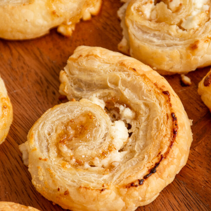 A Fig and Goat Cheese Puff Pastry Pinwheel close up on a wooden serving tray.