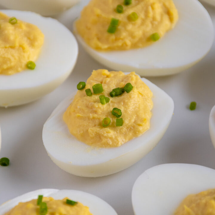 Plate of Horseradish Deviled Eggs topped with chopped chives.