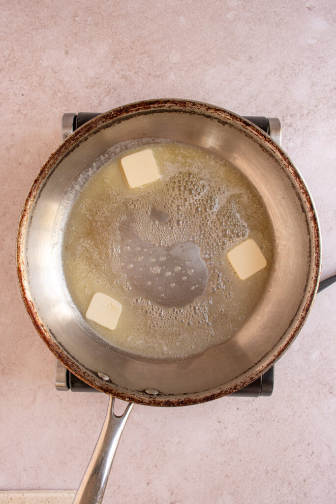 A skillet with melting butter.